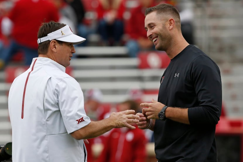 Oklahoma head coach Bob Stoops, left, talks with Texas Tech head coach Kliff Kingsbury,...