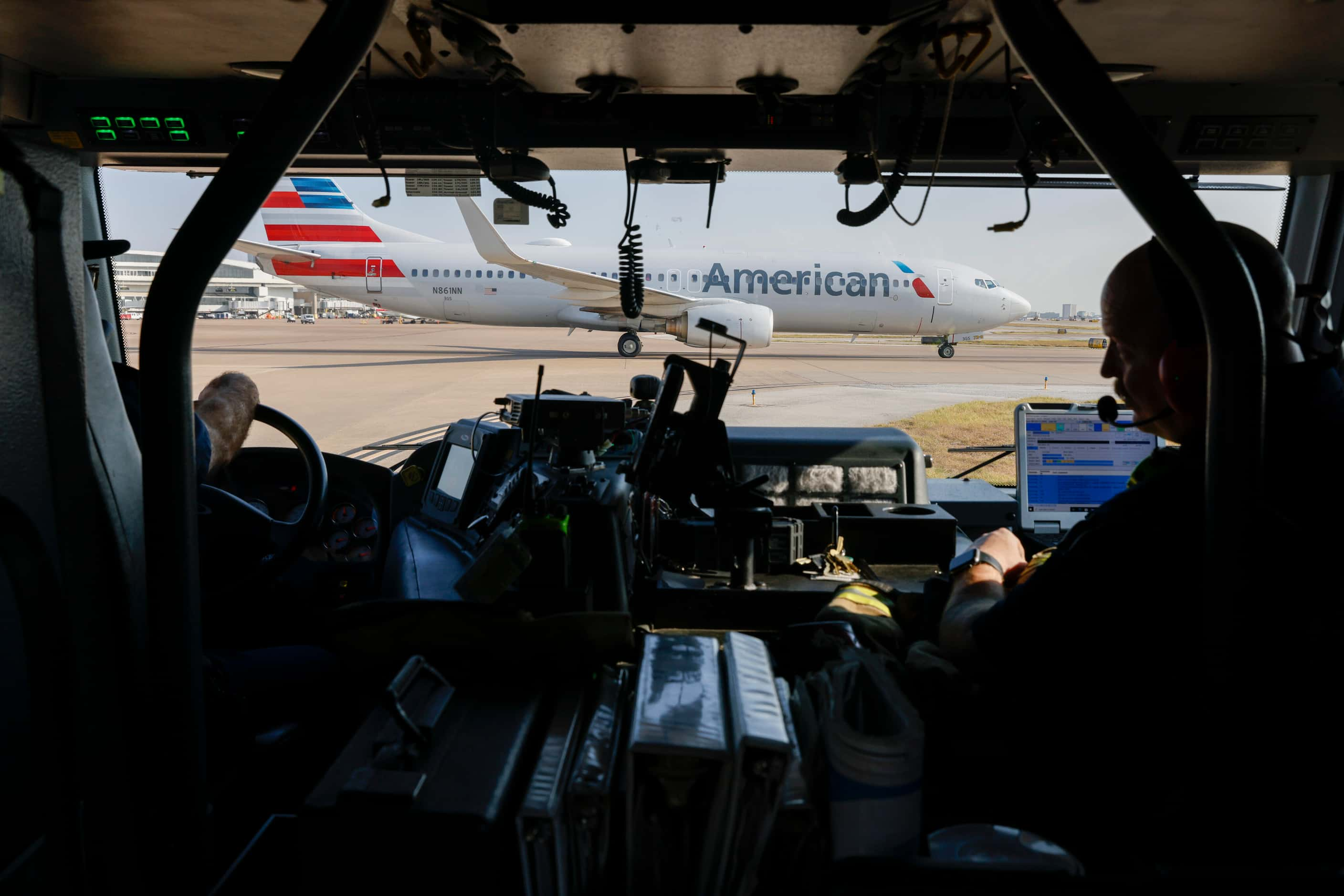 DFW Airport Fire Department firefighters stage near a runway while responding to a call as...