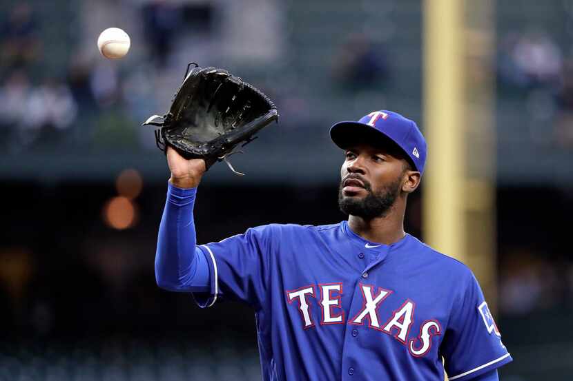 Texas Rangers starting pitcher Taylor Hearn reaches for a ball tossed to him against the...