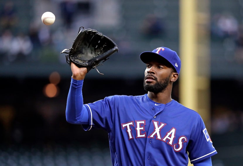 Texas Rangers starting pitcher Taylor Hearn reaches for a ball tossed to him against the...