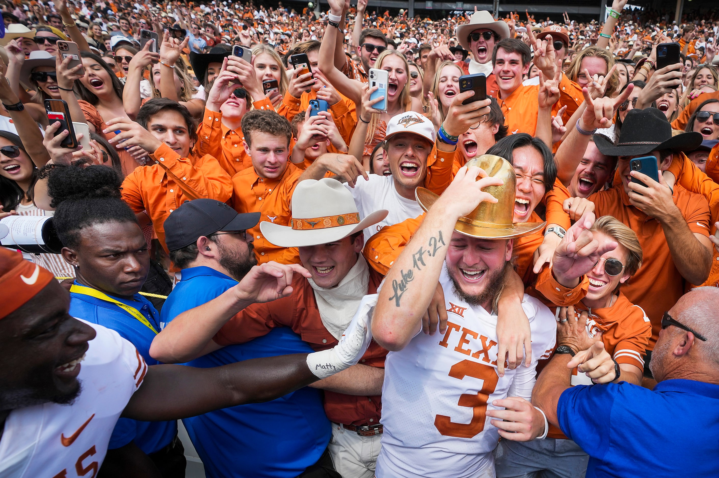 Texas quarterback Quinn Ewers dons the Golden Hat trophy as he celebrates with fans after a...