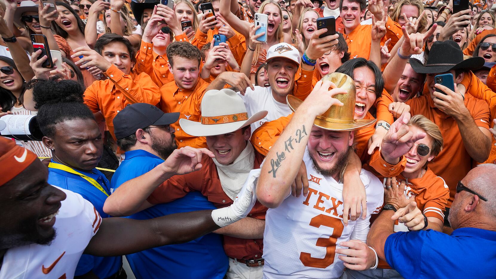 Texas quarterback Quinn Ewers dons the Golden Hat trophy as he celebrates with fans after a...