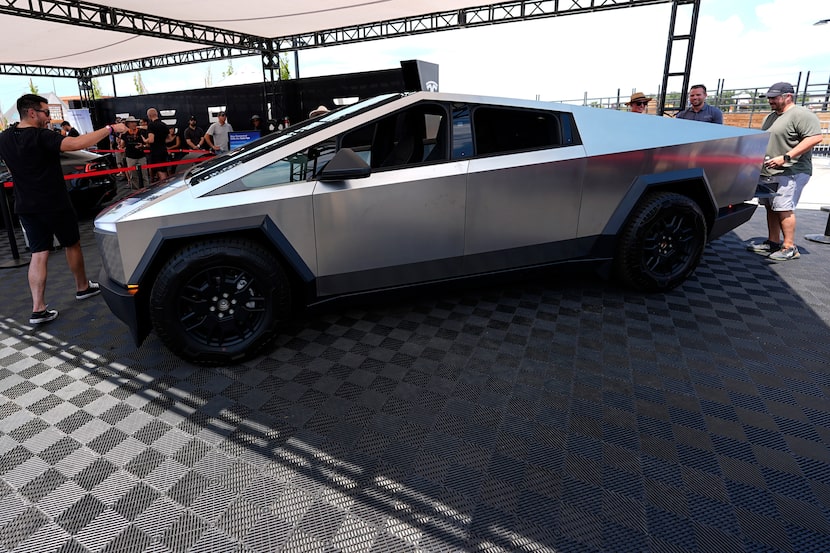 FILE - Visitors look over a 2024 Cybertruck in the Tesla display at the Electrify Expo, July...