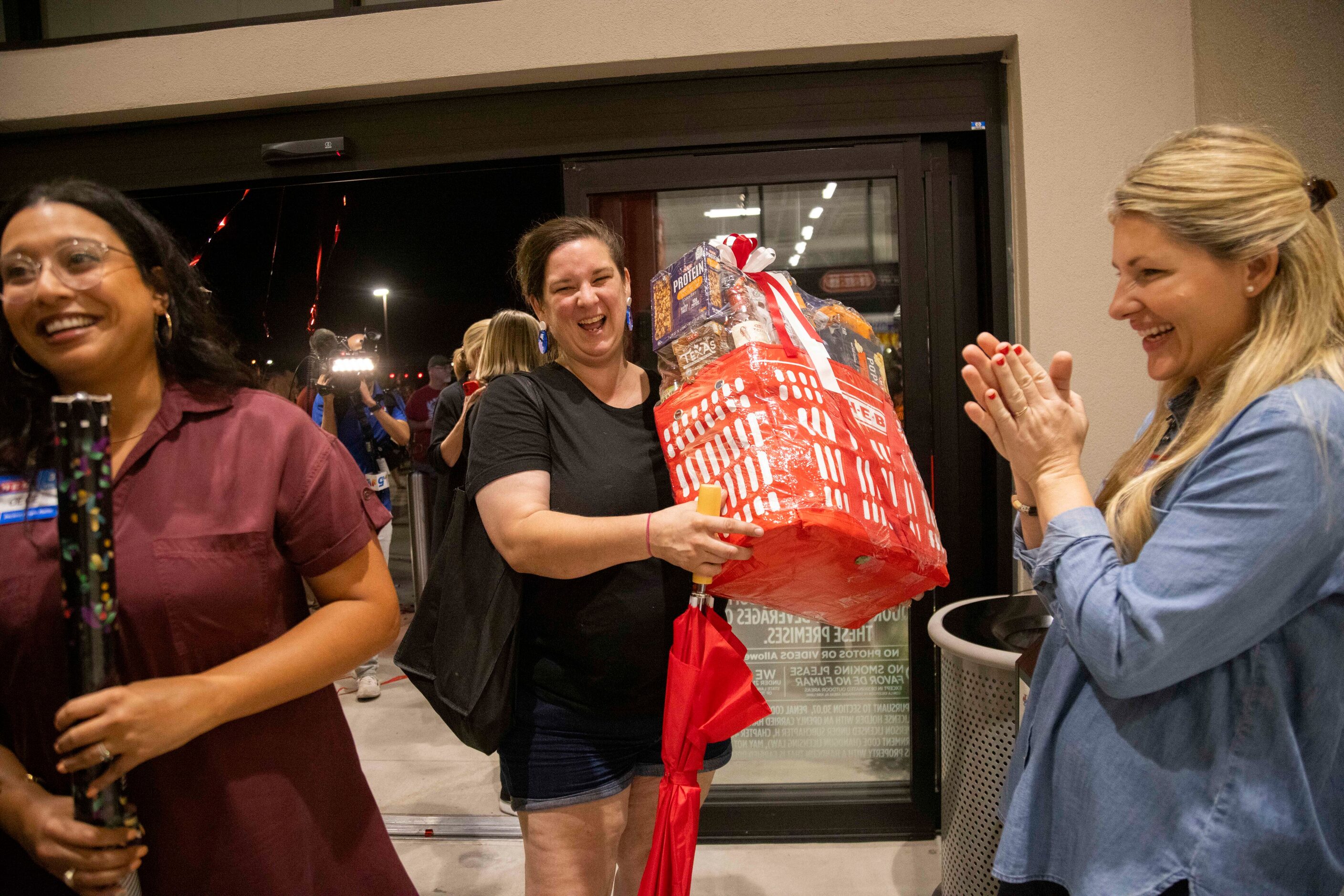 Ashlei Trammell, who had been in line since 3 pm yesterday, receives a gift basket for being...