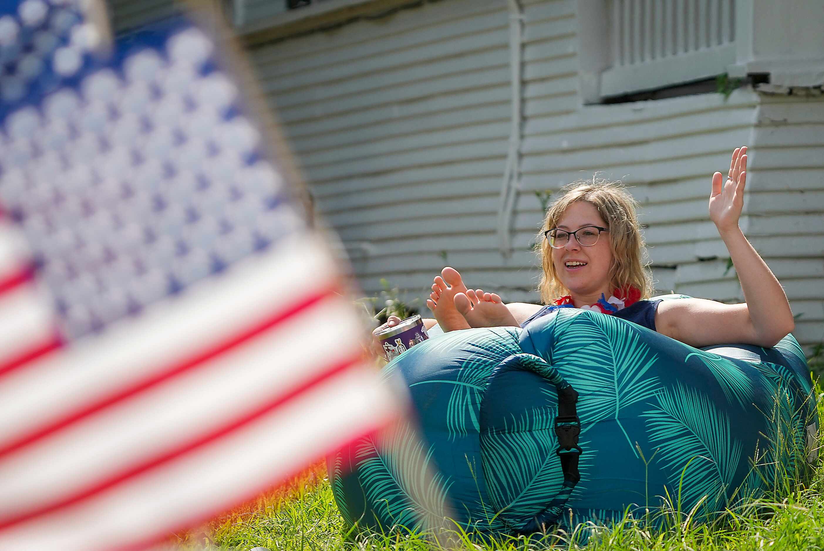 Spectator Maggie Hartman waves to parade participants from the comfort of an inflatable...