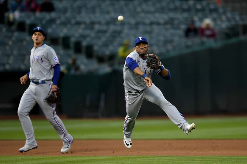 OAKLAND, CALIFORNIA - MAY 26: Andy Ibanez #77 of the Texas Rangers throws to first for the...