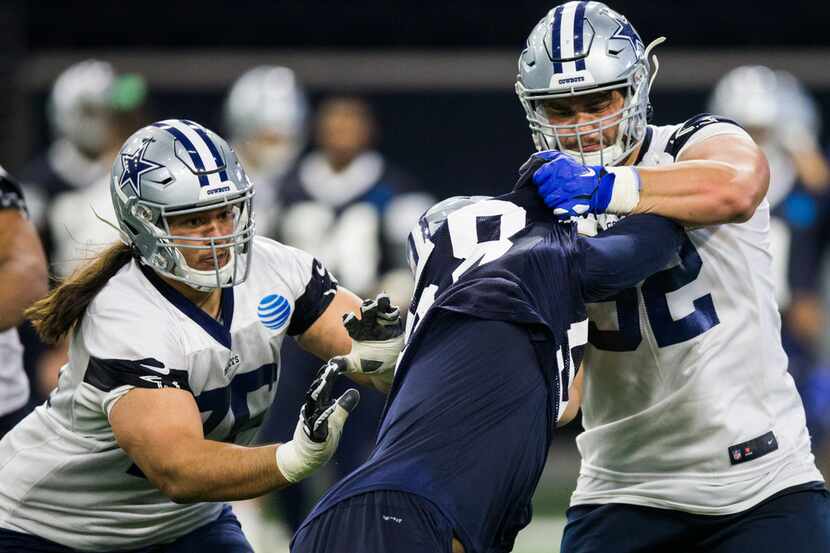 Defensive end Robert Quinn (58) and guard Connor Williams (52, right) collide during a...