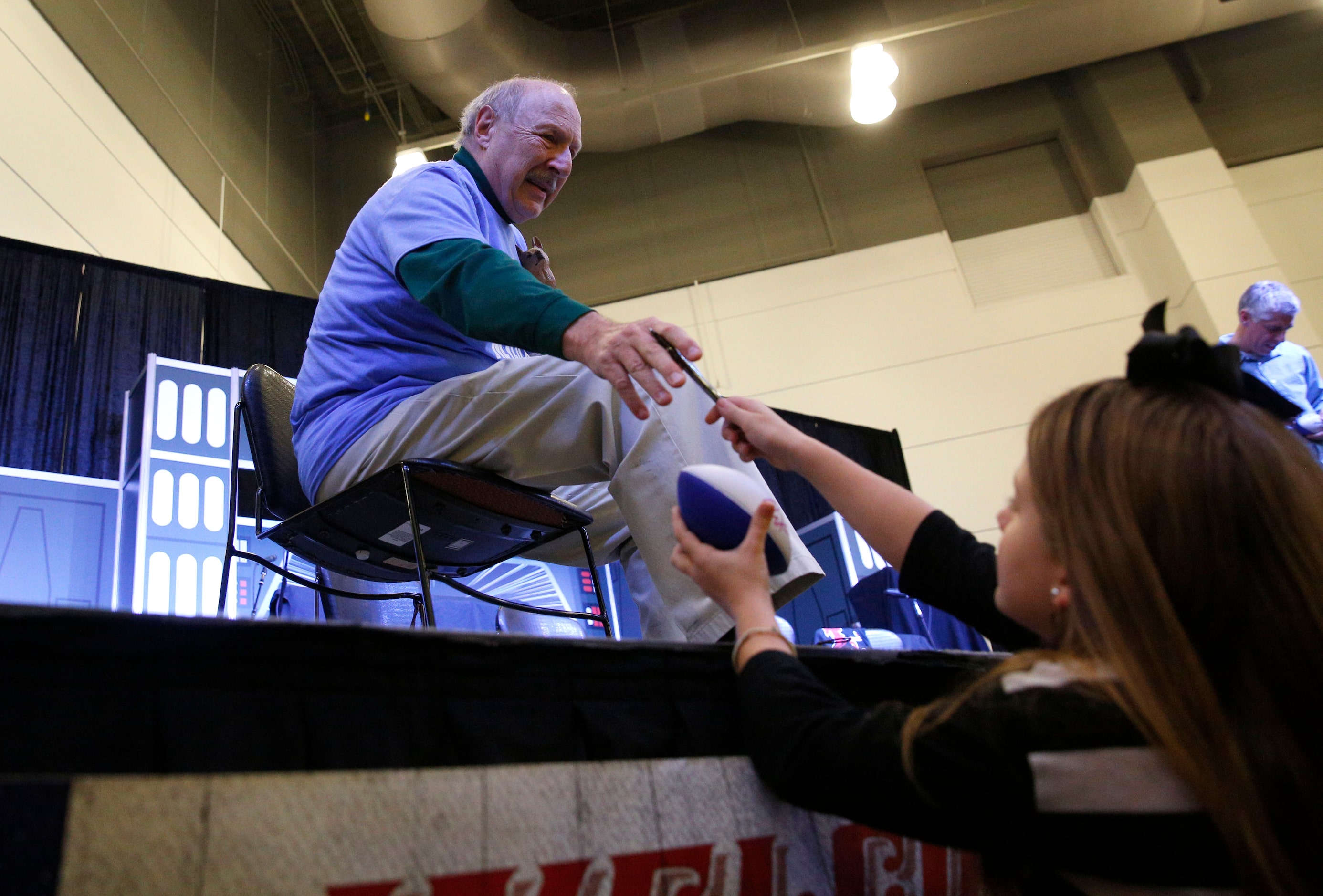 Norm Hitzges signs his autograph for Kimber Kiedrowski, 9, at The Ticket Sportradio's...