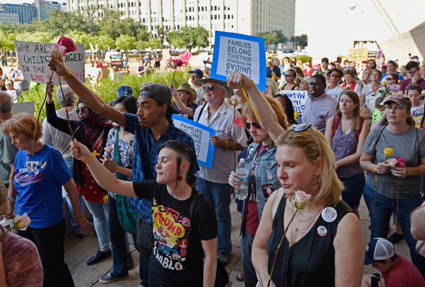 People raise their fists as an activist speaks during a protest against the U.S....