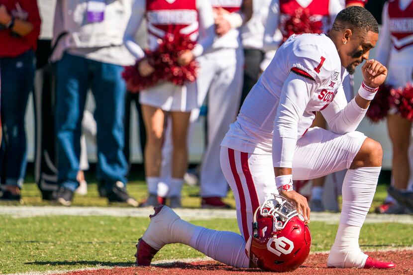 Oklahoma quarterback Jalen Hurts (1) prays on the field before an NCAA football game between...