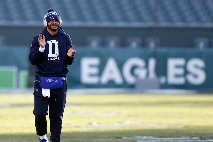 Dallas Cowboys quarterback Dak Prescott (4) claps as he walks up the field before warmups...