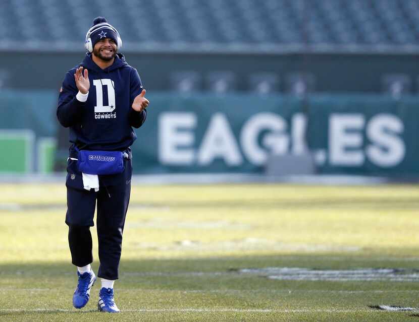 Dallas Cowboys quarterback Dak Prescott (4) claps as he walks up the field before warmups...