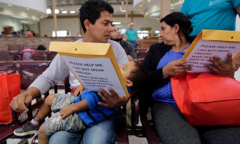  Guatemalans seeking asylum looked over travel packets as they waited at the bus station in...