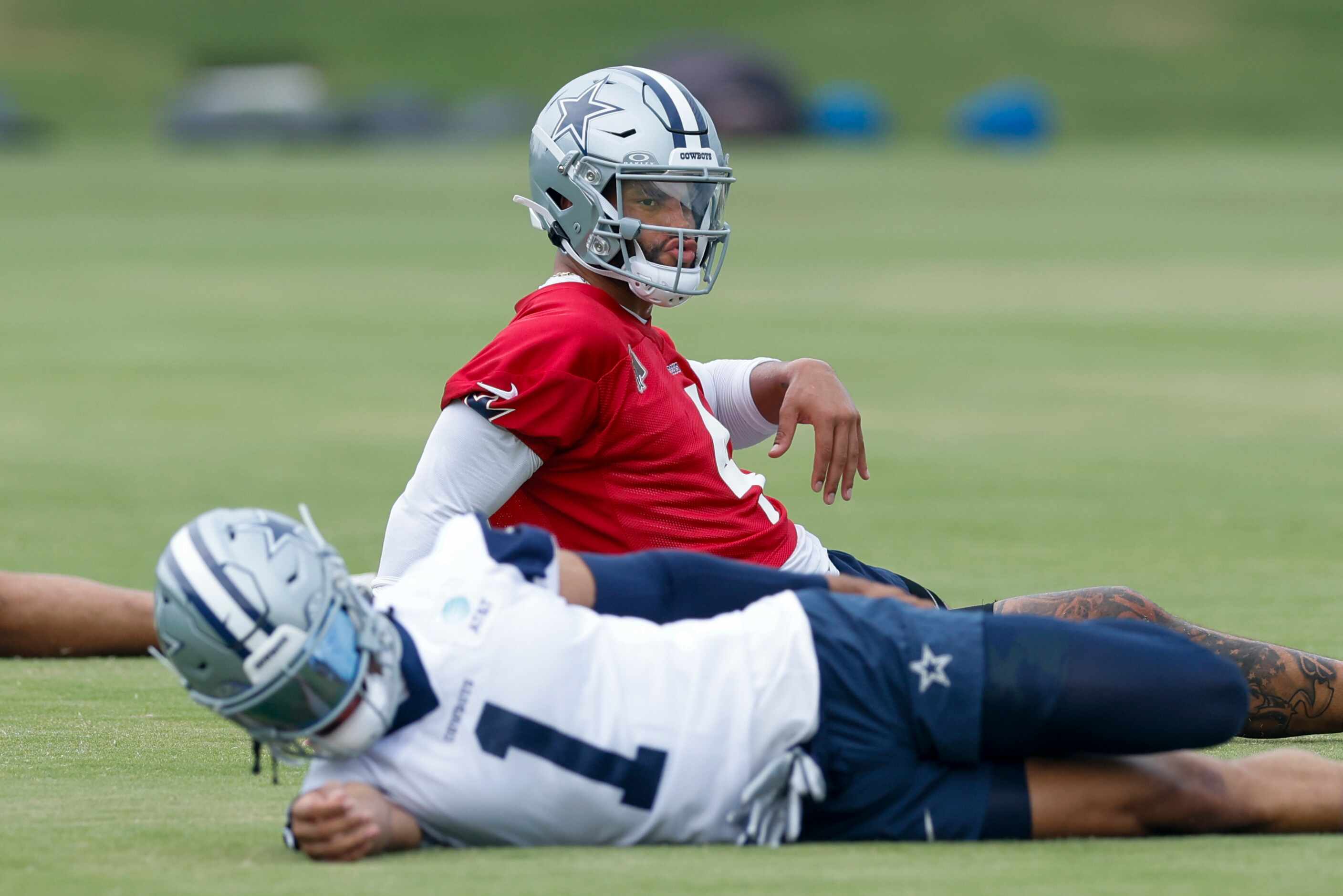 Dallas Cowboys quarterback Dak Prescott (4) dances as he stretches during the team's OTA...