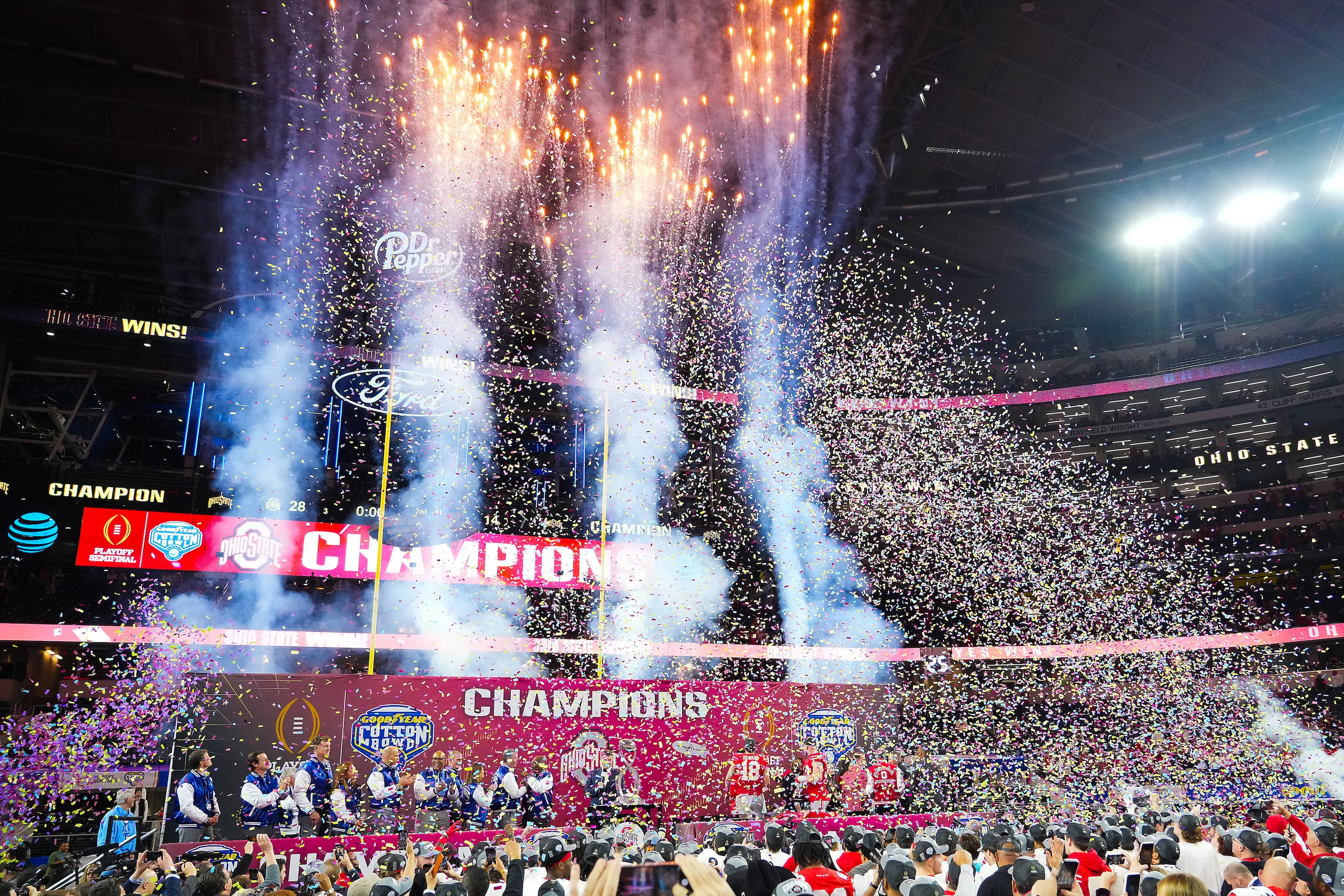 Fireworks explode and confetti covers the awards podium as Ohio State players celebrate...