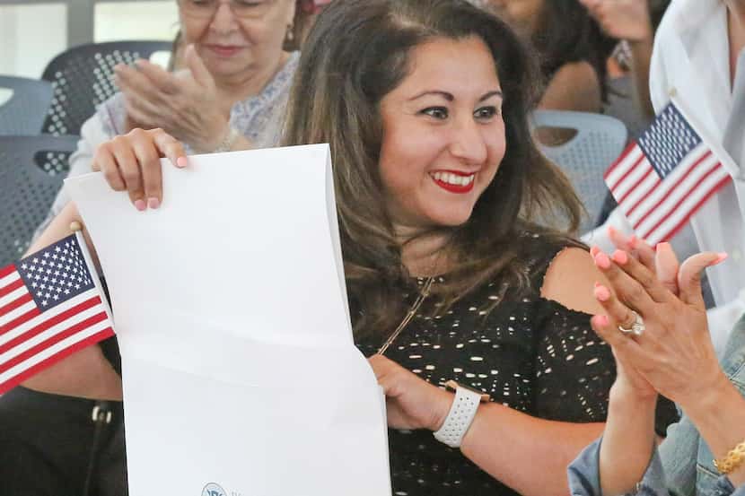 Karina Almaguer, originalmente de Ecuador, sonríe luego de la ceremonia de naturalización....