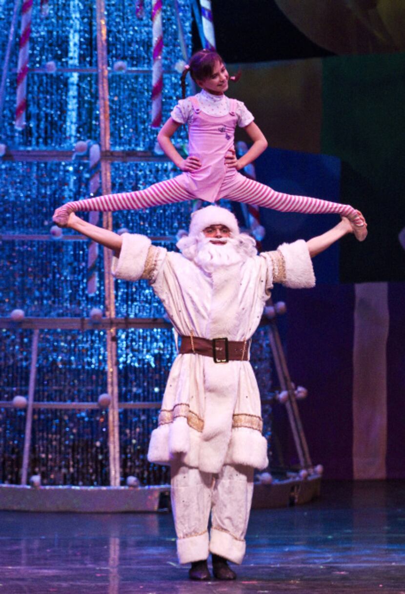 Performers dressed as Santa and Santa's little helper perform acrobats during a performance...
