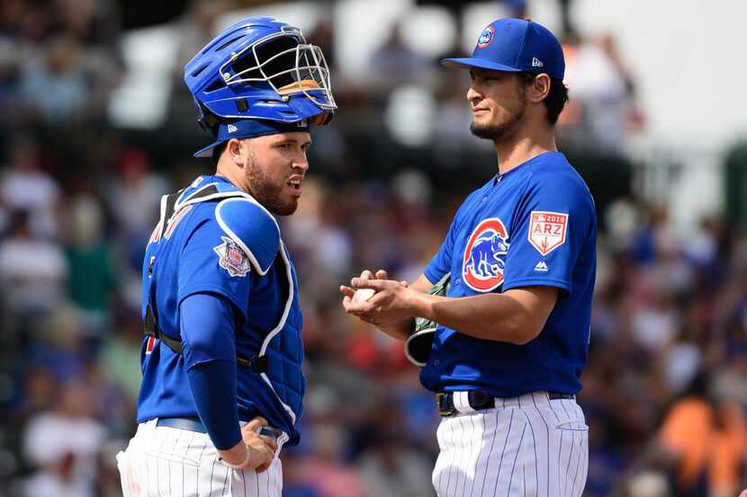 MESA, ARIZONA - FEBRUARY 26: Yu Darvish #11 of the Chicago Cubs reacts alongside Victor...