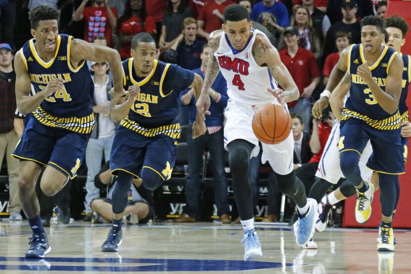 Southern Methodist Mustangs guard Keith Frazier (4) fast breaks past four Michigan defenders...