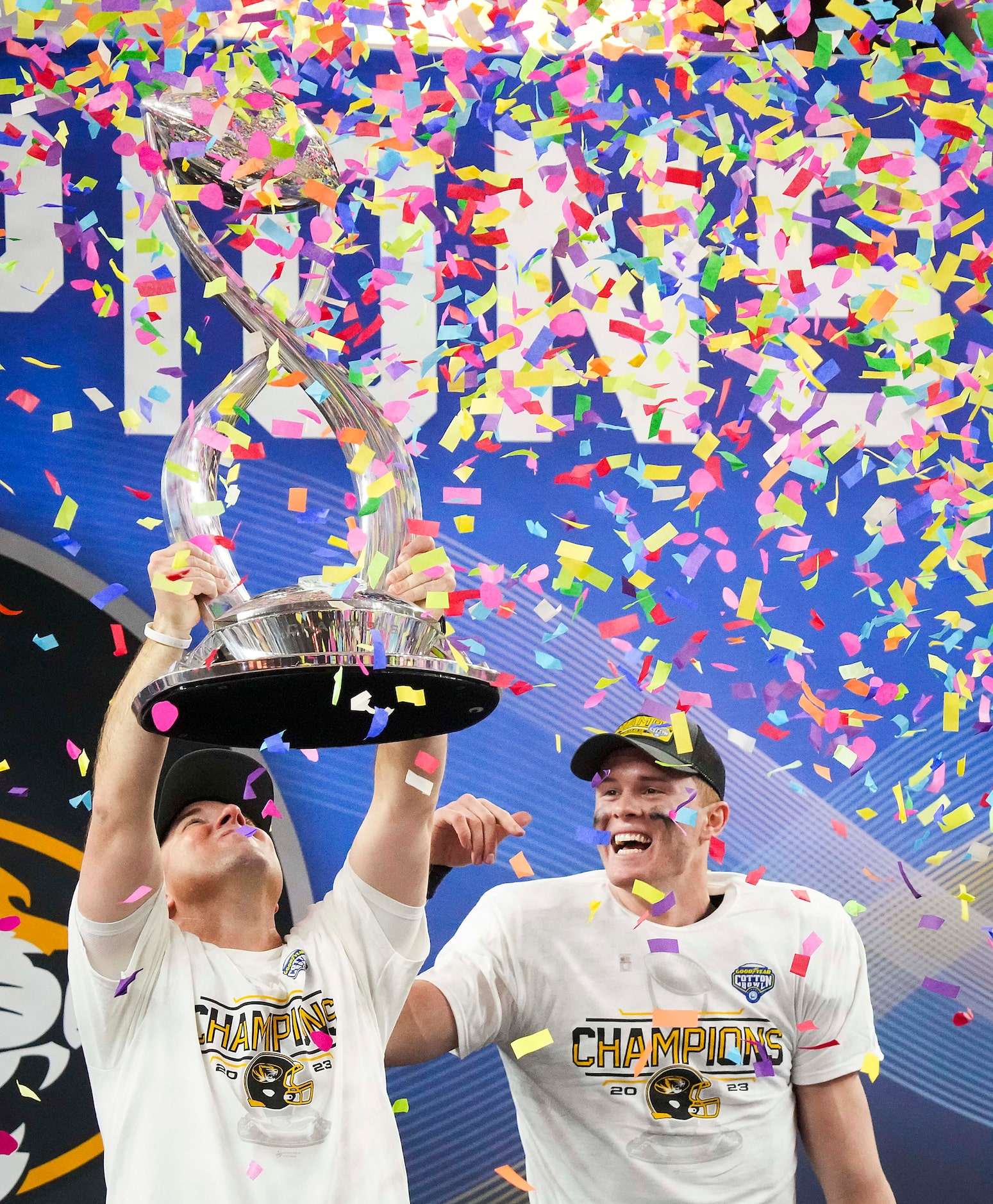 Missouri head coach Eliah Drinkwitz lifts the trophy alongside quarterback Brady Cook  after...