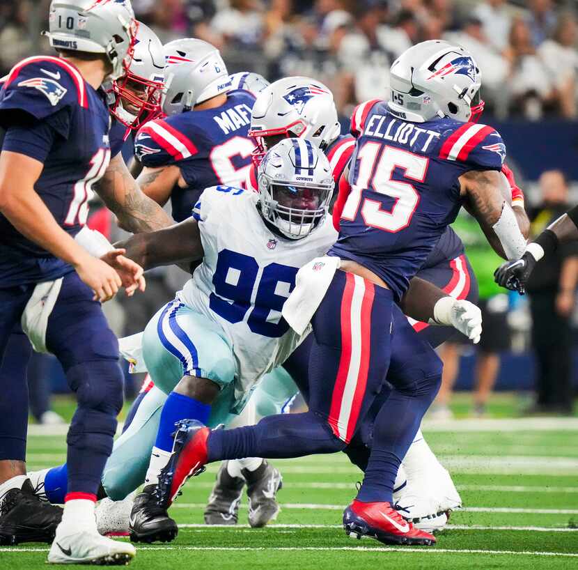 New England Patriots running back Ezekiel Elliott (15) is brought down by Dallas Cowboys...