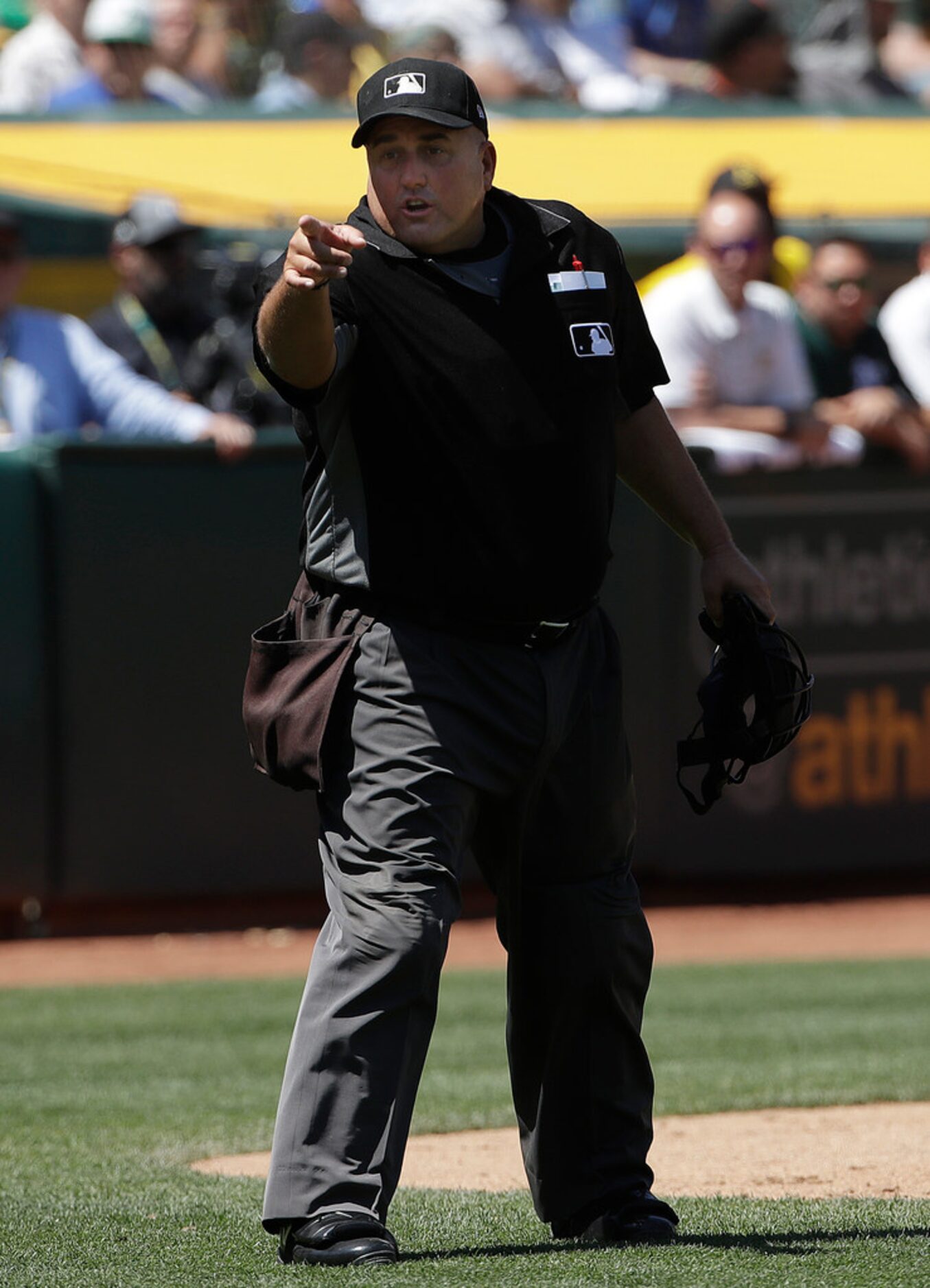 Home plate umpire Eric Cooper gestures toward a player in the Texas Rangers dugout during...