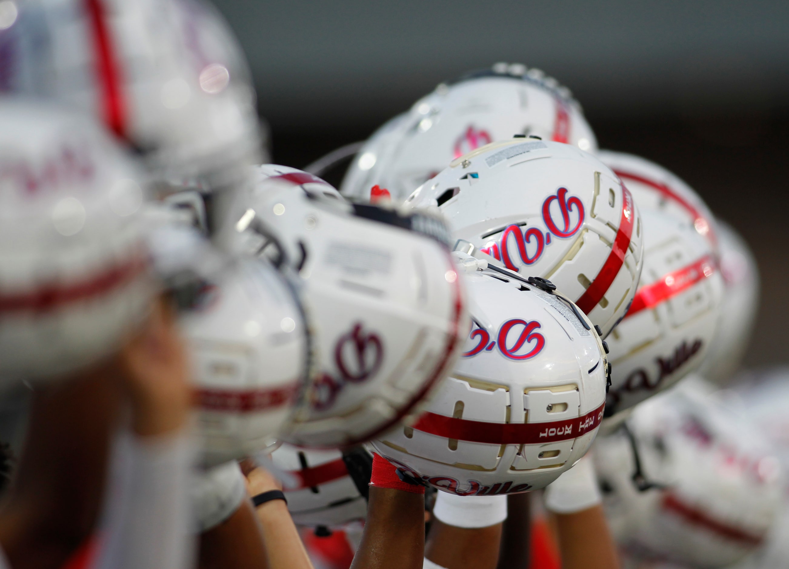 Duncanville players raise their helmets after the playing of the national anthem prior to...