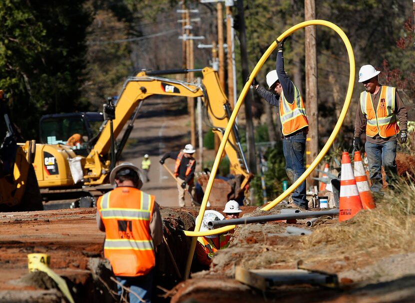 FILE - In this Oct. 18, 2019, file photo, Pacific Gas and Electric Company, workers bury...