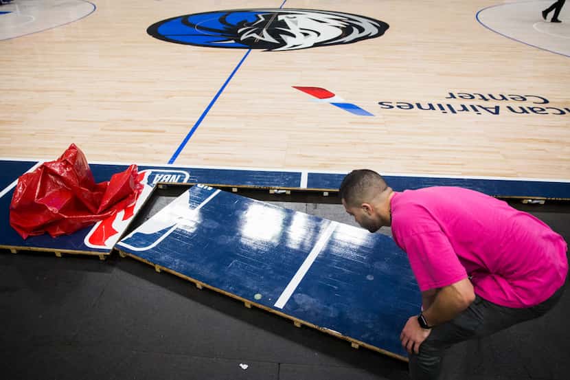 Crews break down the court after the Dallas Mavericks beat the Denver Nuggets 113-97 on...