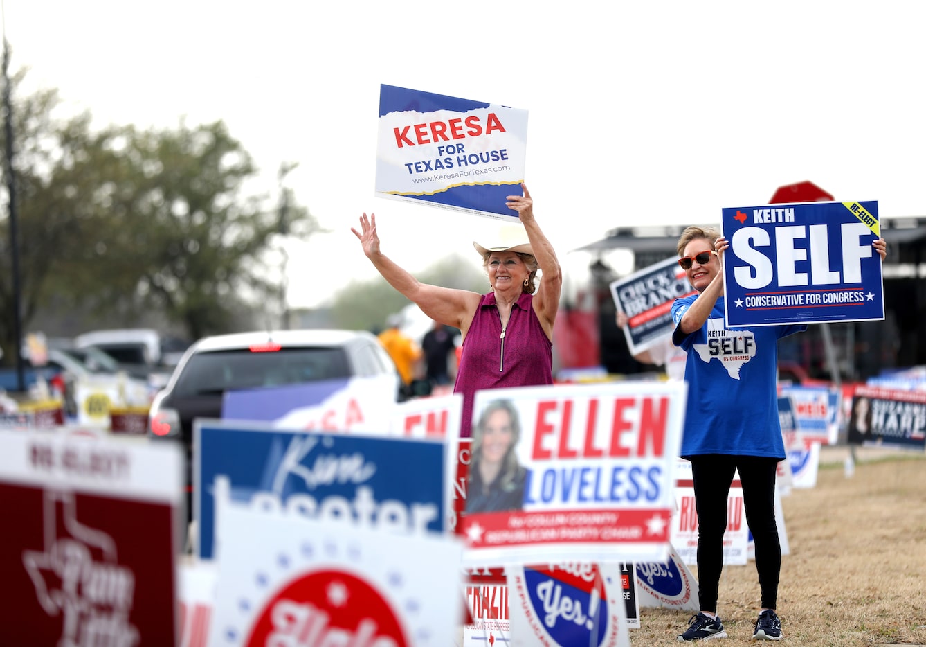 Lynne Harding, left and Carol Ownby wave at cars coming into the John and Judy Gay Public...