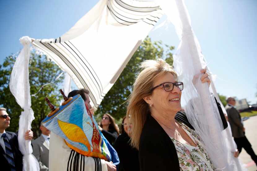 Debbe Katz, sister of Wende Weinberg, helps carry the chupah that covers the torah made...