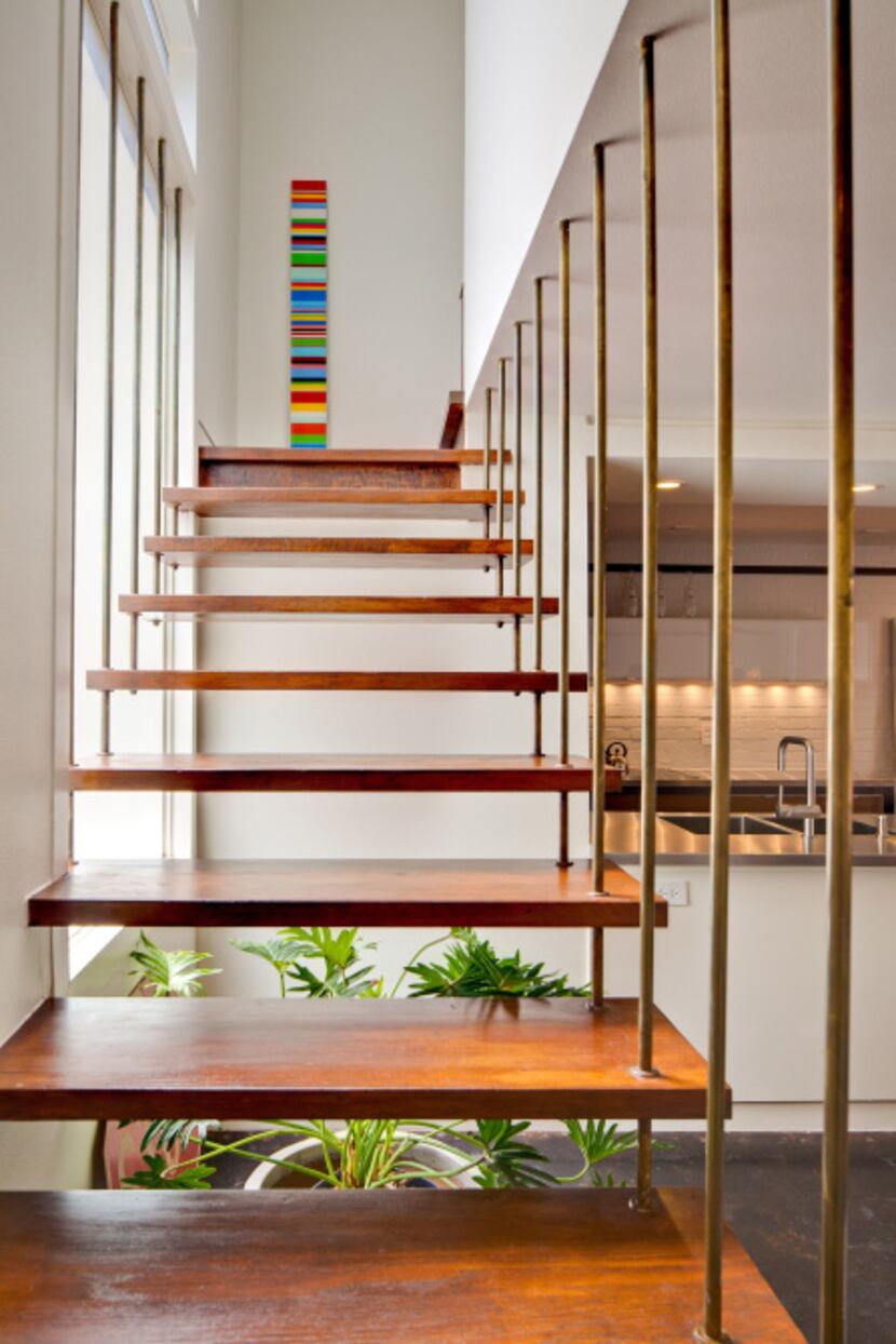A wall of glass near an open staircase that let in lots of natural light is a feature of...