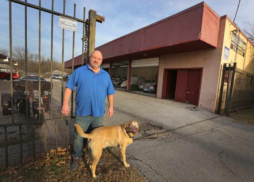 Owner Kevin Prestridge of Merriman Park Automotive is pictured at his business with his dog...