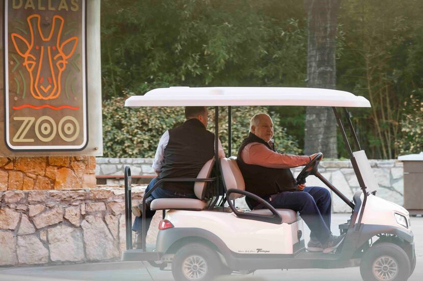 Dallas Zoo President and CEO Gregg Hudson, right, drives a cart with Harrison Edell,...
