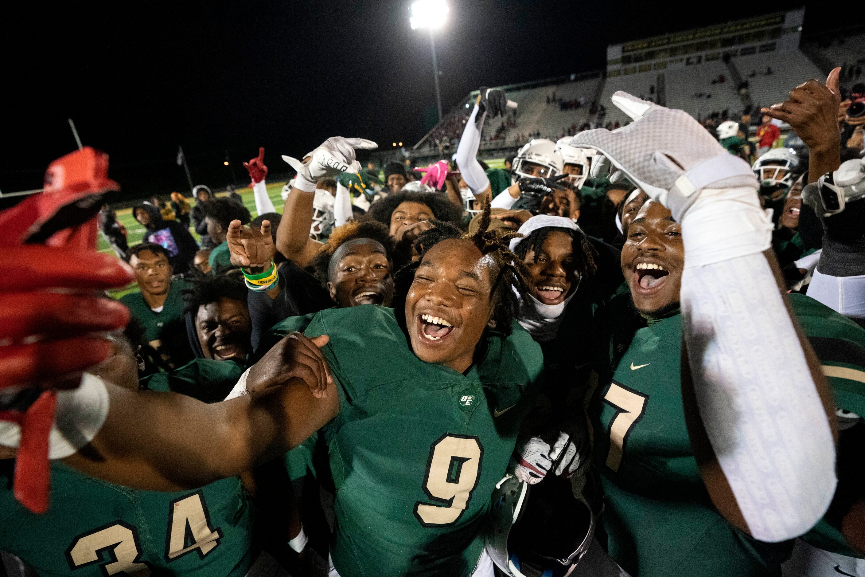 DeSoto junior wide receiver Dahlyn Jones (9), center, celebrates with teammates after...