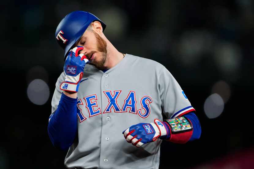 Texas Rangers' Jonah Heim reacts after grounding out to end the top of the sixth inning of...