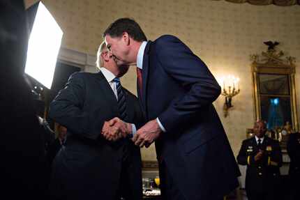 President Donald Trump shook hands with then FBI Director James Comey at a reception in...
