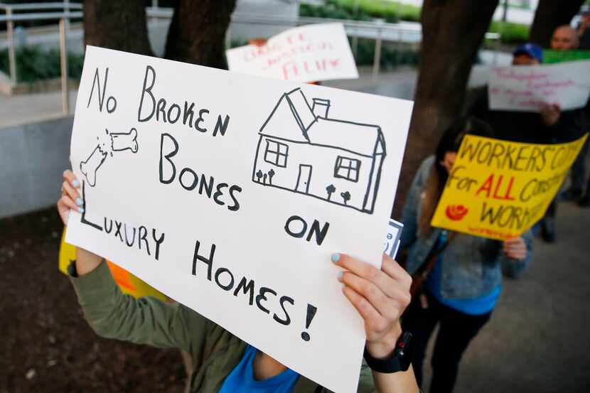 Protesters carried signs outside First Texas Homes' office in Uptown Dallas on Feb. 24,...