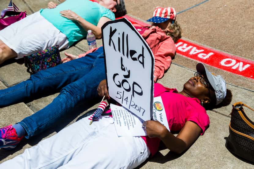 Protesters lay on the ground as part of a "die-in," where they pretend to be dead, during a...