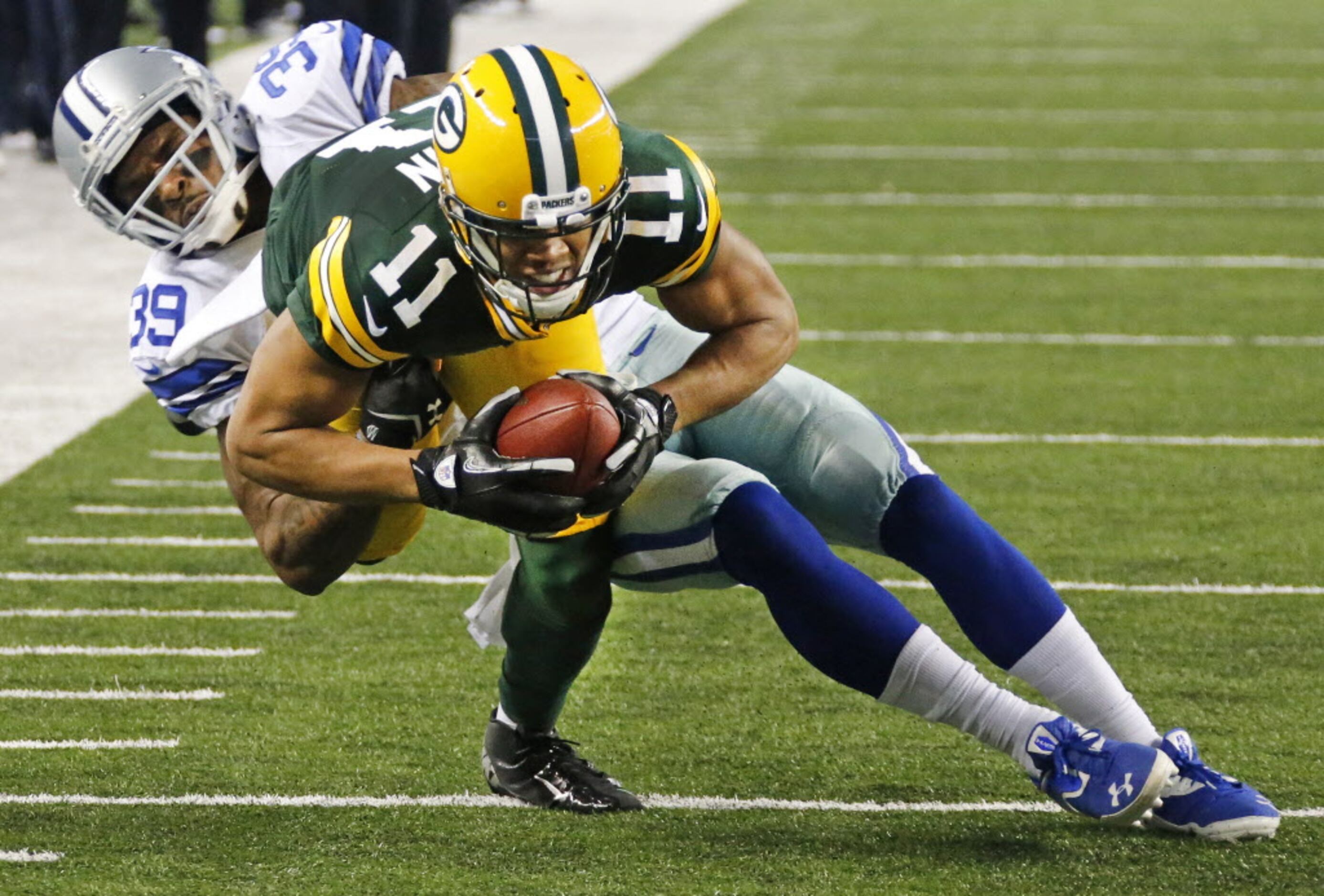 Dallas Cowboys DeMarcus Ware offers a hand to Green Bay Packers quarterback  Matt Flynn during the