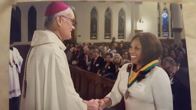 Auxiliary Bishop Gregory Kelly congratulated Myrna Dartson in 2017 after the Dallas diocese...