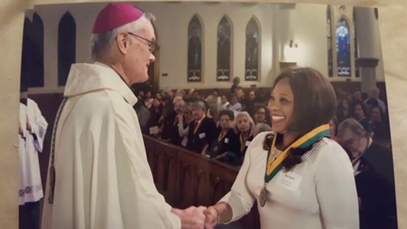 Auxiliary Bishop Gregory Kelly congratulated Myrna Dartson in 2017 after the Dallas diocese...