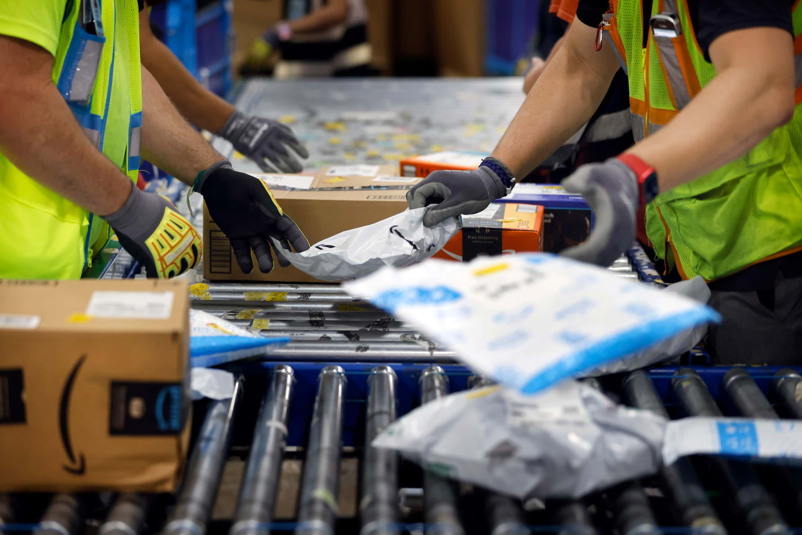 Crew members sort early PRIME day deal packages as they arrive via trucks at one of the...