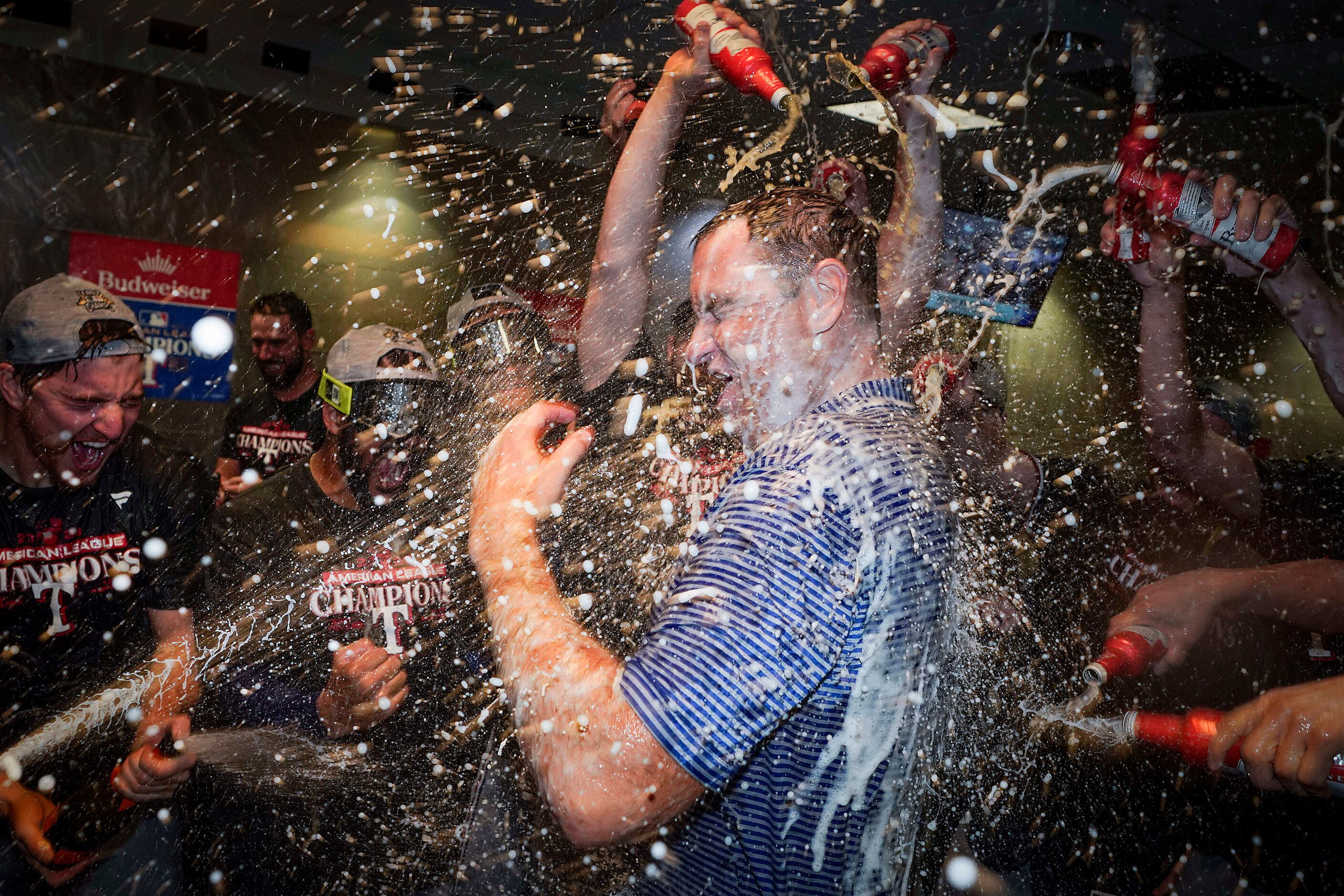 Texas Rangers general manager Chris Young is doused as player celebrates in the clubhouse...