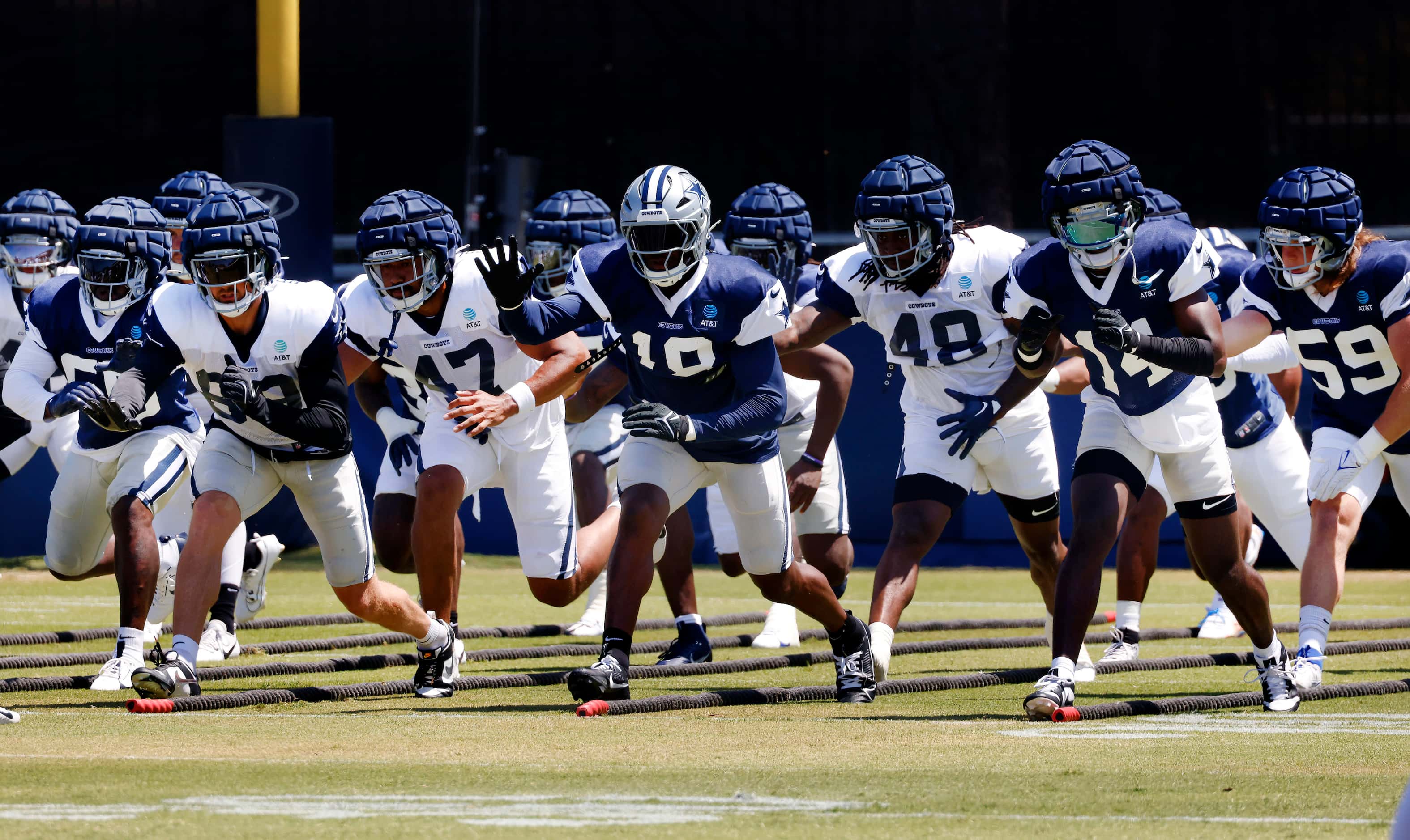 Dallas Cowboys offensive and defensive players lunge at the snap of the ball during training...