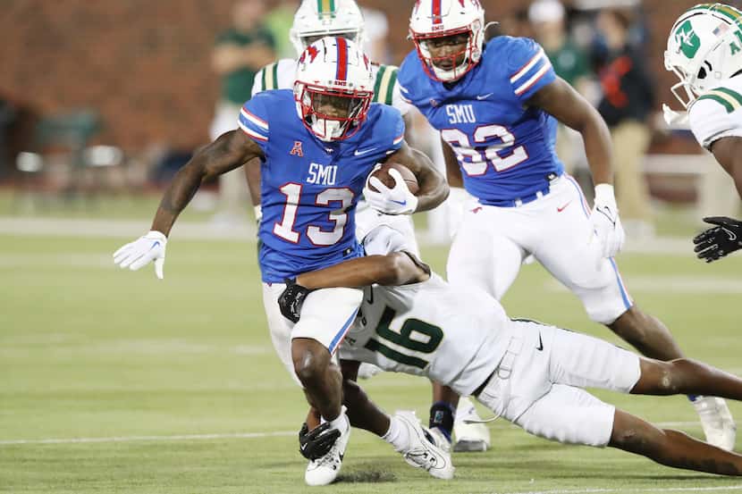 Football player for SMU running with the ball and being tackled.