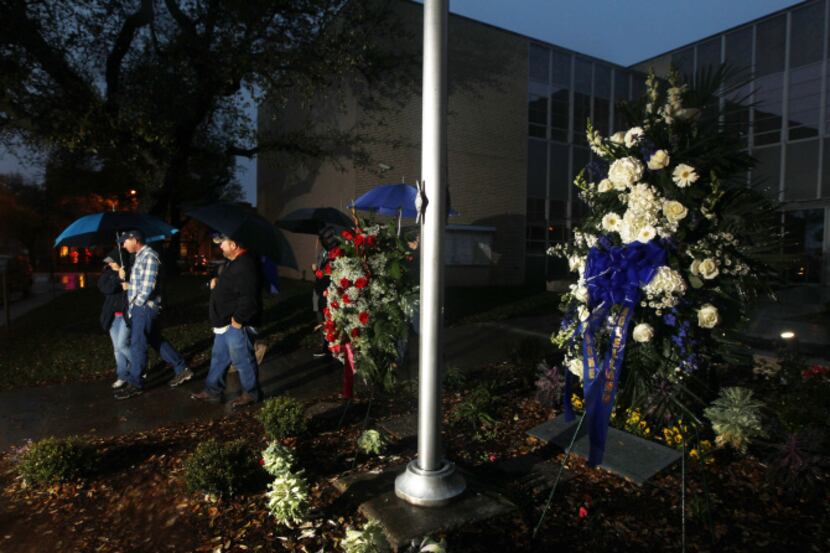 An evening prayer group walked past two wreaths placed in front of the Kaufman County...