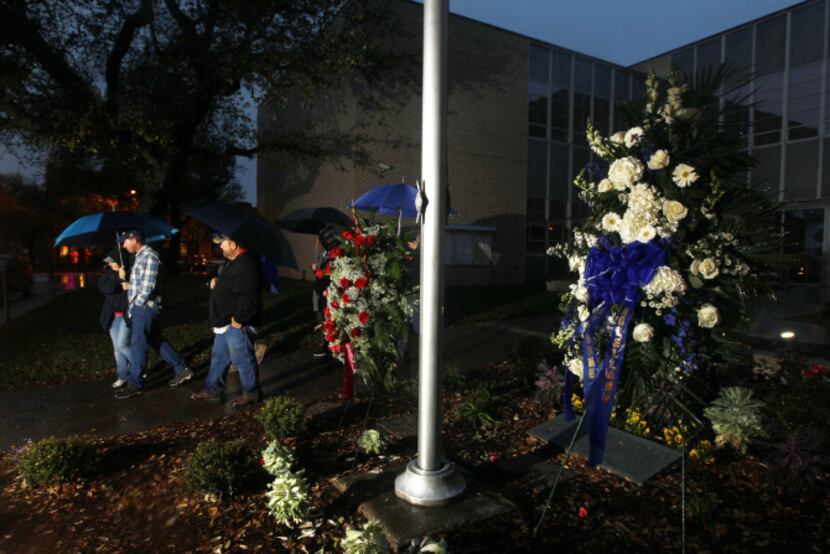 An evening prayer group walked past two wreaths placed in front of the Kaufman County...