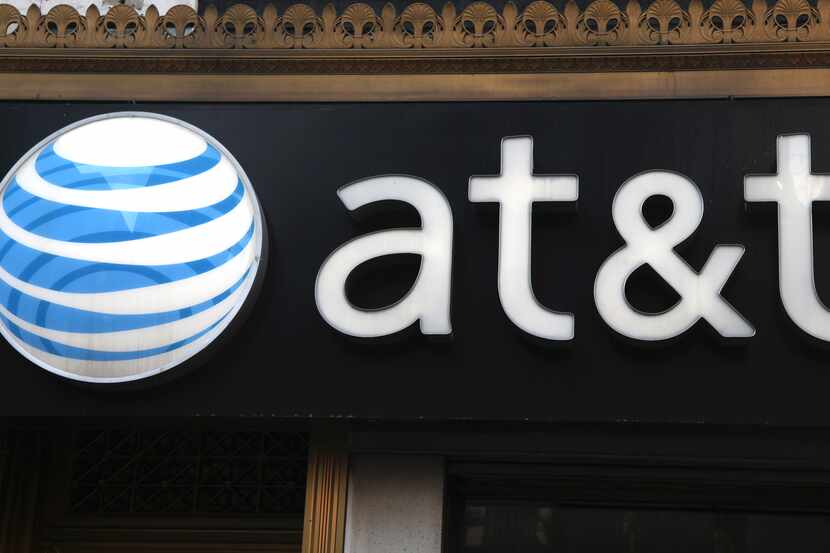 FILE-This May 6, 2012, file photo, shows an AT&T sign at a store in New York. Following in...