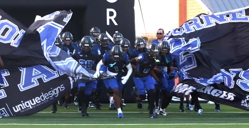 North Forney players emerge from a spirit sign just prior to their game against Royse City....